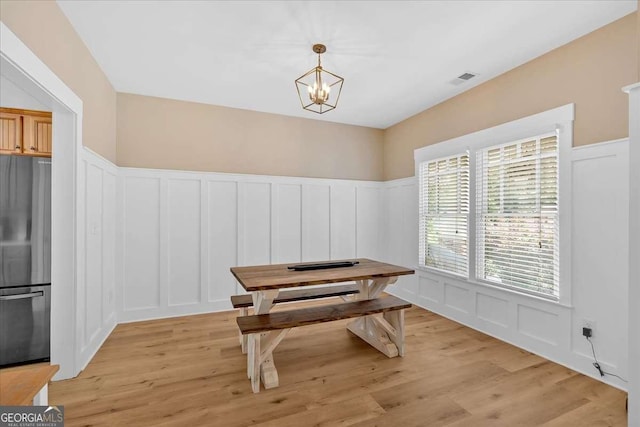 60 Independence Ave, Dallas, GA 30132 - dining space featuring a decorative wall, a chandelier, a wainscoted wall, and light wood-type flooring