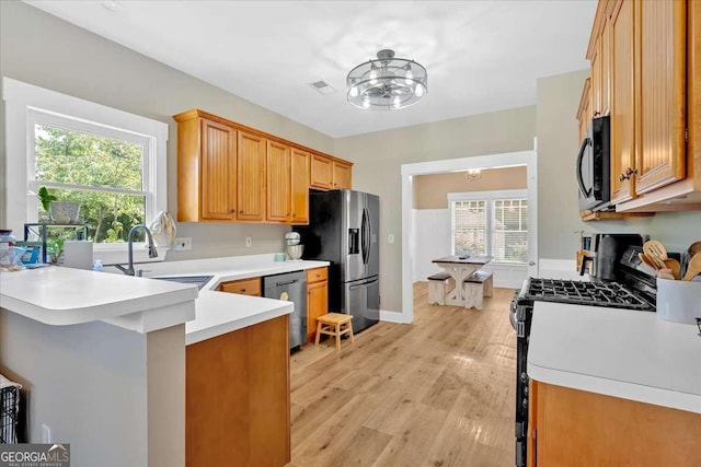 60 Independence Ave, Dallas, GA 30132 - kitchen with appliances with stainless steel finishes, a sink, light countertops, a peninsula, and light wood-style floors