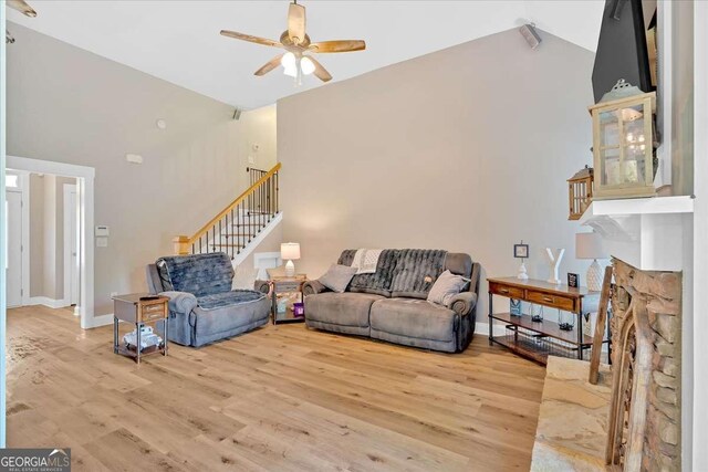60 Independence Ave, Dallas, GA 30132 - living room featuring high vaulted ceiling, a ceiling fan, stairway, wood finished floors, and a stone fireplace
