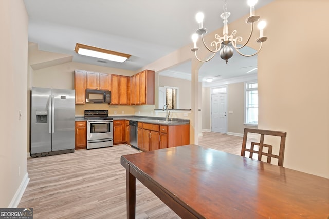 111 Moonlight Trl, Port Wentworth, GA 31407 - kitchen with appliances with stainless steel finishes, a chandelier, a sink, dark countertops, and light wood-style flooring