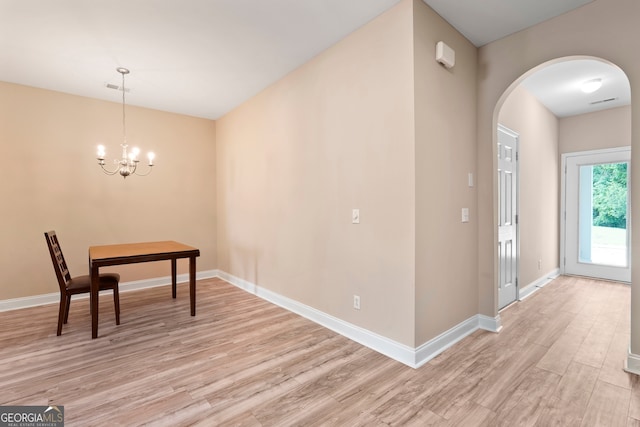 111 Moonlight Trl, Port Wentworth, GA 31407 - unfurnished dining area with arched walkways, light wood-style flooring, a chandelier, and baseboards