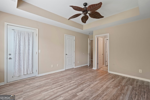 111 Moonlight Trl, Port Wentworth, GA 31407 - unfurnished bedroom with a raised ceiling, light wood-style flooring, baseboards, and a ceiling fan