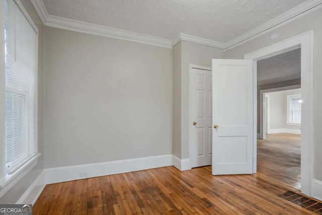 1615 Stokes Ave SW, Atlanta, GA 30310 - empty room with wood-type flooring, crown molding, and a textured ceiling