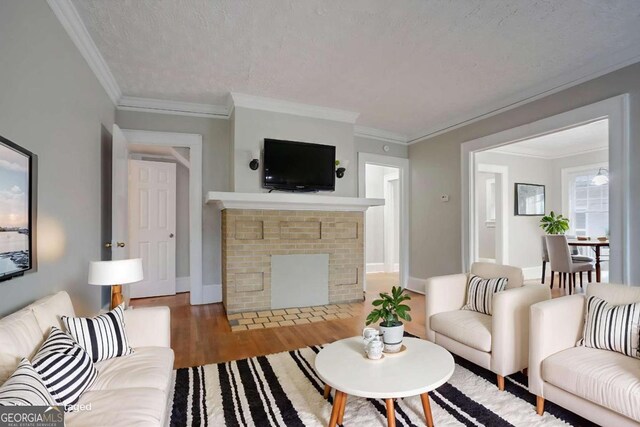 1615 Stokes Ave SW, Atlanta, GA 30310 - living room with wood finished floors, a brick fireplace, crown molding, and a textured ceiling