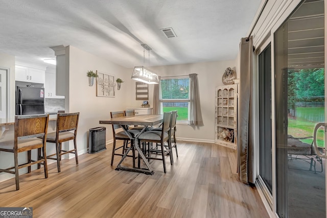 10 1st Ave E, Newnan, GA 30265 - dining area featuring baseboards, light wood finished floors, and a textured ceiling