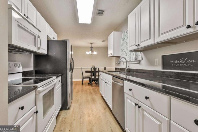 40 Moore Rd, Newnan, GA 30263 - kitchen with white appliances, a sink, white cabinets, and a chandelier