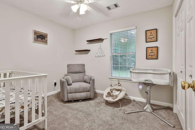 40 Moore Rd, Newnan, GA 30263 - carpeted bedroom with a nursery area, a closet, a textured ceiling, baseboards, and ceiling fan