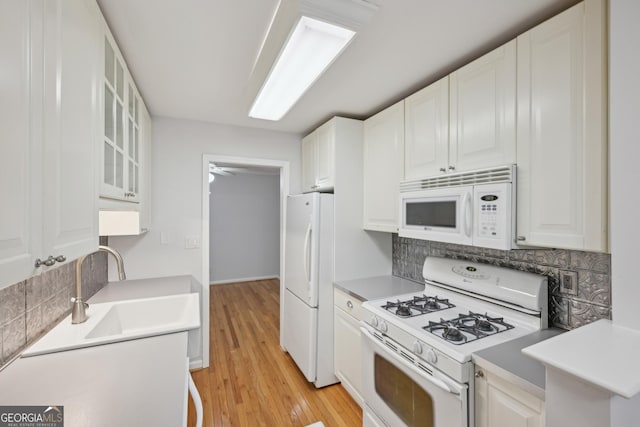 209 14th St NE Unit 109, Atlanta, GA 30309 - kitchen with white appliances, decorative backsplash, glass insert cabinets, and white cabinetry