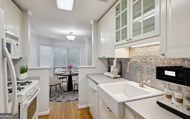209 14th St NE Unit 109, Atlanta, GA 30309 - kitchen featuring white appliances, tasteful backsplash, light wood-style flooring, white cabinetry, and glass insert cabinets