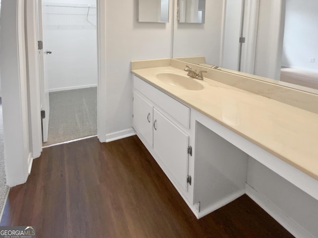 688 Anderson Walk, Marietta, GA 30062 - bathroom featuring vanity, wood finished floors, baseboards, and a walk in closet