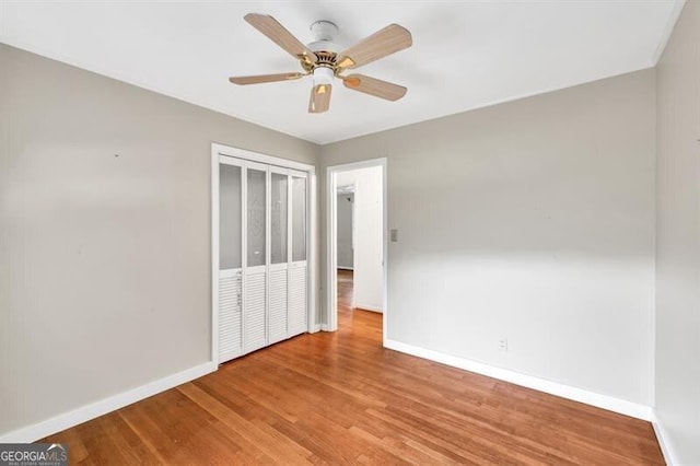 8140 Wood St SE, Covington, GA 30014 - unfurnished bedroom with baseboards, wood finished floors, a closet, and ceiling fan