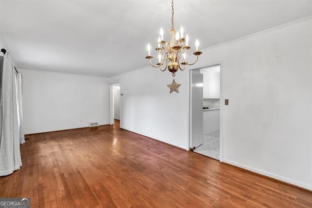 8140 Wood St SE, Covington, GA 30014 - unfurnished dining area with wood finished floors and a chandelier