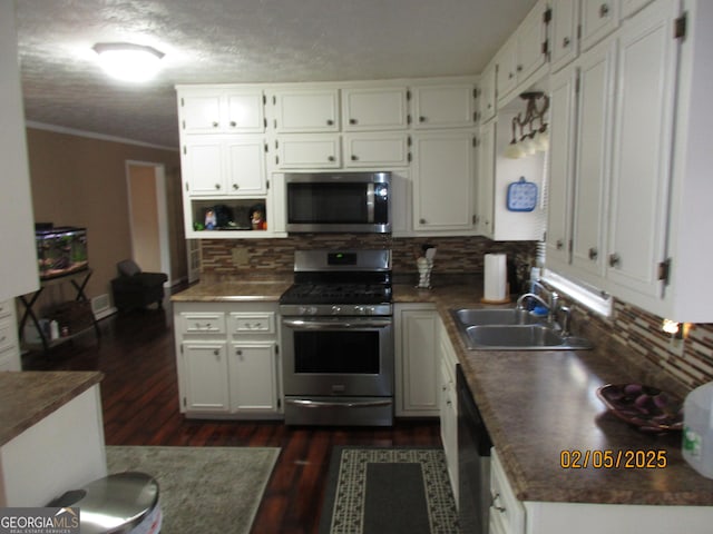 5848 Navarre Ct, Stone Mountain, GA 30087 - kitchen featuring appliances with stainless steel finishes, dark wood-type flooring, backsplash, white cabinets, and ornamental molding