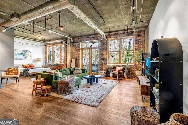 3235 Roswell Rd NE Unit 508, Atlanta, GA 30305 - living area featuring wood finished floors, brick wall, and rail lighting