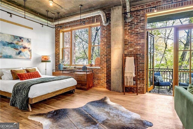 3235 Roswell Rd NE Unit 508, Atlanta, GA 30305 - bedroom featuring a high ceiling, brick wall, wood finished floors, access to exterior, and multiple windows