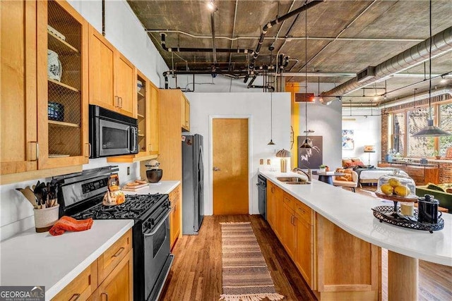 3235 Roswell Rd NE Unit 508, Atlanta, GA 30305 - kitchen with stainless steel appliances, wood finished floors, light countertops, glass insert cabinets, and a peninsula
