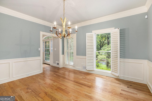 386 Link Rd, Alpharetta, GA 30022 - unfurnished dining area featuring a chandelier, a wainscoted wall, crown molding, a decorative wall, and wood finished floors