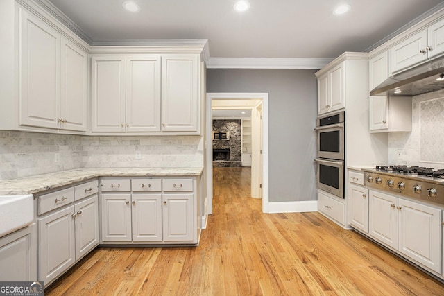386 Link Rd, Alpharetta, GA 30022 - kitchen with appliances with stainless steel finishes, under cabinet range hood, ornamental molding, decorative backsplash, and white cabinetry