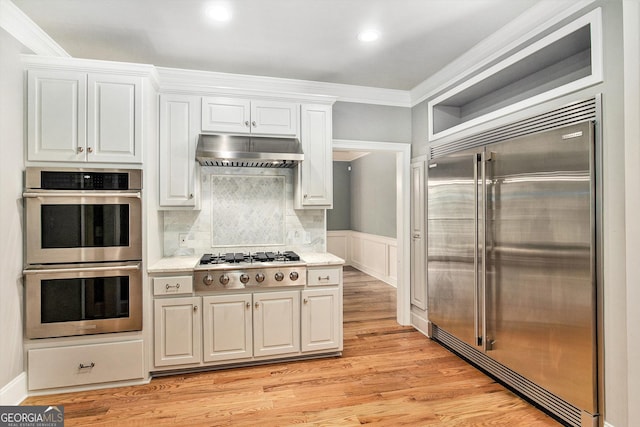 386 Link Rd, Alpharetta, GA 30022 - kitchen with appliances with stainless steel finishes, ventilation hood, crown molding, white cabinetry, and light wood-type flooring