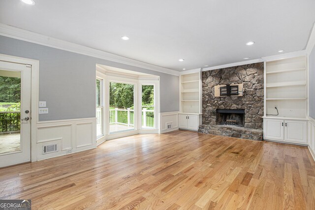386 Link Rd, Alpharetta, GA 30022 - unfurnished living room with ornamental molding, healthy amount of natural light, built in shelves, a fireplace, and wainscoting