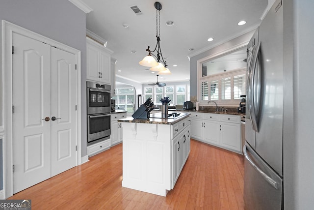 12 Par Dr, Jesup, GA 31546 - kitchen with stainless steel appliances, crown molding, a kitchen island, white cabinets, and light wood-style flooring