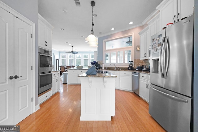 12 Par Dr, Jesup, GA 31546 - kitchen with appliances with stainless steel finishes, white cabinets, a center island, crown molding, and a peninsula
