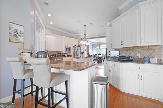 12 Par Dr, Jesup, GA 31546 - kitchen with stainless steel appliances, a peninsula, backsplash, a chandelier, and white cabinets