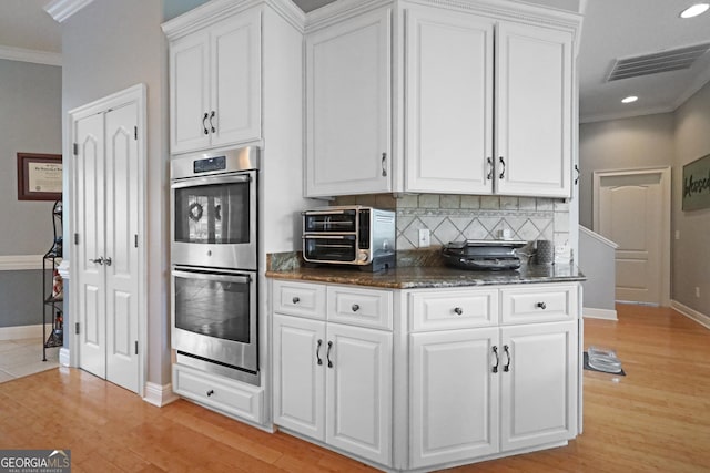 12 Par Dr, Jesup, GA 31546 - kitchen featuring stainless steel double oven, ornamental molding, backsplash, white cabinets, and baseboards