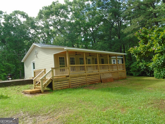 621 Zebulon Rd, Milner, GA 30257 - back of house featuring ceiling fan, a yard, a deck, and view of wooded area