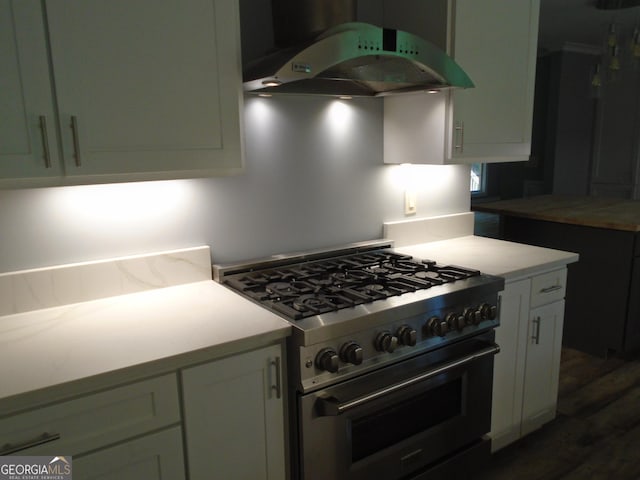 621 Zebulon Rd, Milner, GA 30257 - kitchen with high end stainless steel range, under cabinet range hood, light countertops, dark wood finished floors, and white cabinets