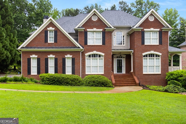 1014 Overlook Dr, Villa Rica, GA 30180 - georgian-style home with a chimney, a front lawn, brick siding, and roof with shingles