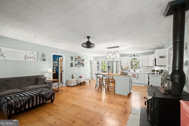 366 Crabapple Rdg, Clarkesville, GA 30523 - living room with a wood stove, light wood-type flooring, and a textured ceiling