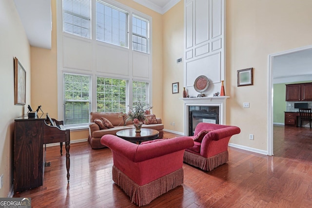 251 Sumac Trl, Woodstock, GA 30188 - living room with a towering ceiling, plenty of natural light, a fireplace, wood finished floors, and ornamental molding