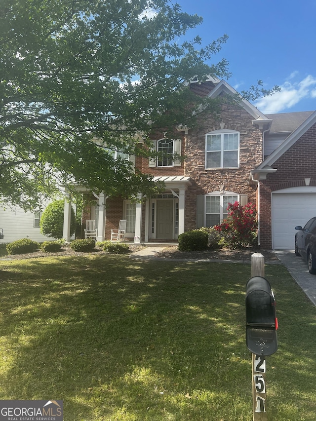 251 Sumac Trl, Woodstock, GA 30188 - view of front of property featuring a front yard, covered porch, brick siding, and an attached garage