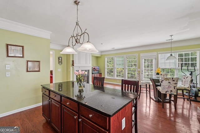 251 Sumac Trl, Woodstock, GA 30188 - kitchen featuring dark brown cabinets, dark wood-type flooring, crown molding, hanging light fixtures, and a kitchen island