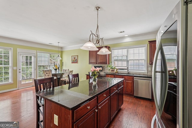 251 Sumac Trl, Woodstock, GA 30188 - kitchen with appliances with stainless steel finishes, plenty of natural light, a kitchen bar, ornamental molding, and a center island