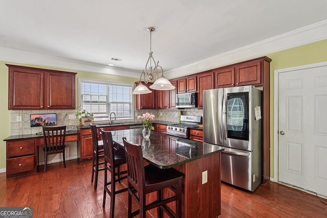 251 Sumac Trl, Woodstock, GA 30188 - kitchen featuring stainless steel appliances, ornamental molding, a kitchen island, tasteful backsplash, and decorative light fixtures
