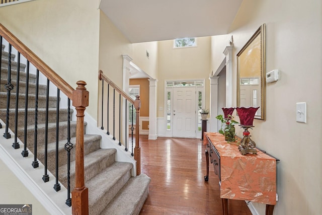 251 Sumac Trl, Woodstock, GA 30188 - foyer featuring decorative columns, plenty of natural light, hardwood / wood-style flooring, stairway, and a high ceiling