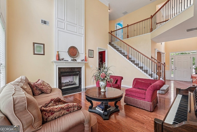 251 Sumac Trl, Woodstock, GA 30188 - living room with a towering ceiling, stairs, a high end fireplace, and wood finished floors