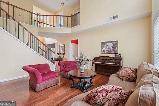 251 Sumac Trl, Woodstock, GA 30188 - living room with wood finished floors, stairs, a towering ceiling, and ornate columns