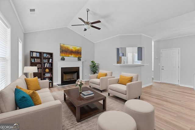 3315 Brookfield Dr, Austell, GA 30106 - living room with light wood-type flooring, ceiling fan, a fireplace with raised hearth, baseboards, and lofted ceiling