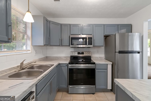 4651 Garden Hills Dr, Stone Mountain, GA 30083 - kitchen with stainless steel appliances, a sink, light countertops, gray cabinets, and light tile patterned floors