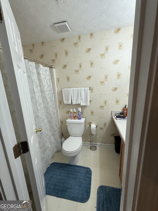 6550 Wellington Chase Ct, Lithonia, GA 30058 - bathroom featuring toilet, vanity, wallpapered walls, a textured ceiling, and a shower with shower curtain