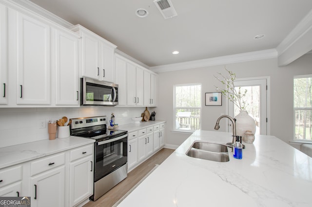 778 Laurel Cove Dr, Hoschton, GA 30548 - kitchen featuring stainless steel appliances, a sink, white cabinetry, backsplash, and light wood-style flooring