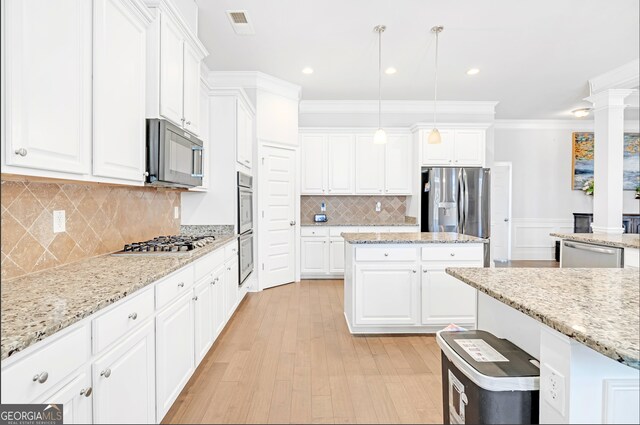 4580 Cloister Cir, Hampton, GA 30228 - kitchen featuring stainless steel appliances, crown molding, decorative columns, white cabinetry, and light wood-type flooring