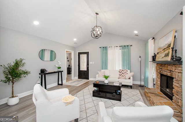 238 Knob Hill Dr, Locust Grove, GA 30248 - living room featuring light wood finished floors, vaulted ceiling, a chandelier, a fireplace, and baseboards