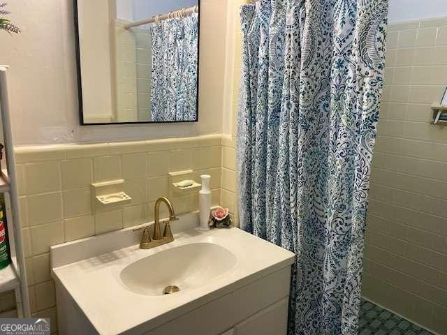 1470 Dunn Rd, Cumming, GA 30040 - full bathroom with a tile shower, tile walls, vanity, and a wainscoted wall