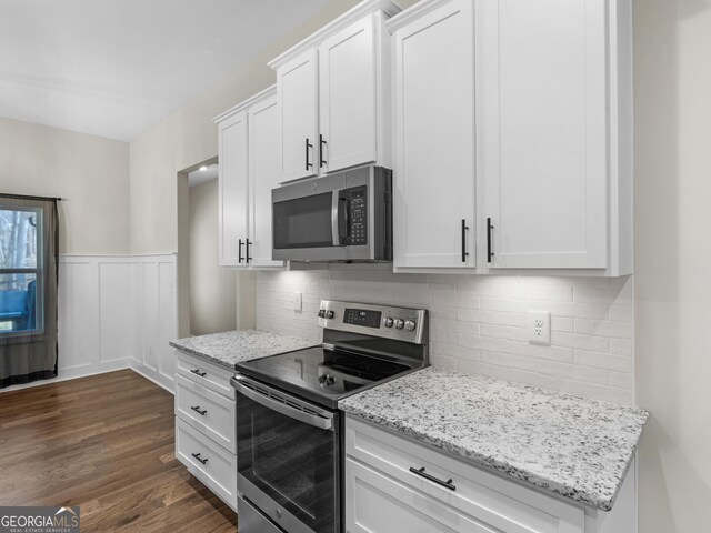 1847 Davis Mill Rd N, Dallas, GA 30157 - kitchen with stainless steel appliances, dark wood-style floors, white cabinetry, a wainscoted wall, and light stone countertops
