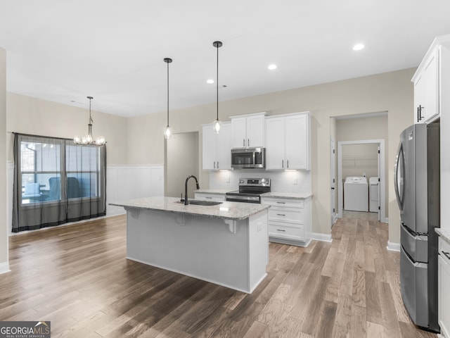 1847 Davis Mill Rd N, Dallas, GA 30157 - kitchen with appliances with stainless steel finishes, separate washer and dryer, a sink, a kitchen breakfast bar, and a chandelier