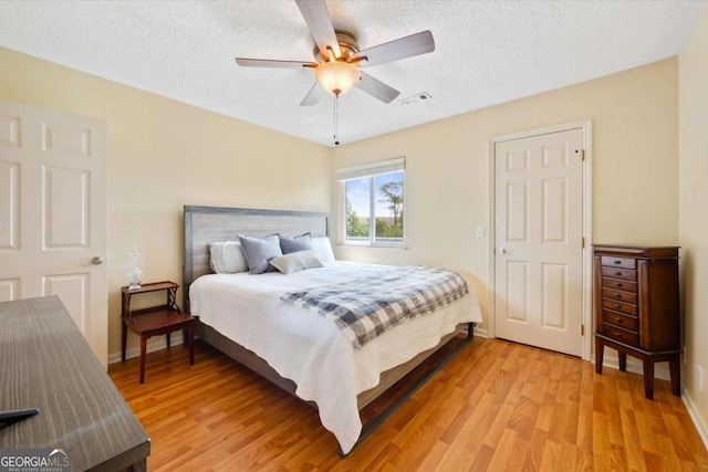 226 Bull River Bluff Dr, Savannah, GA 31410 - bedroom with light wood-style floors, a textured ceiling, and ceiling fan